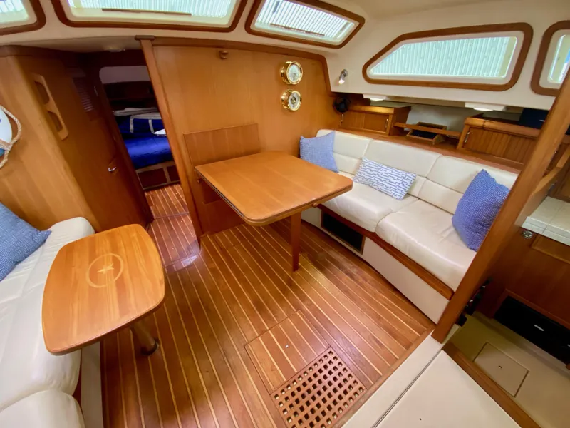 Slide: The Image of 2006 Island Packet 485 Center Cockpit interior with wood finish and comfortable seating. - 28