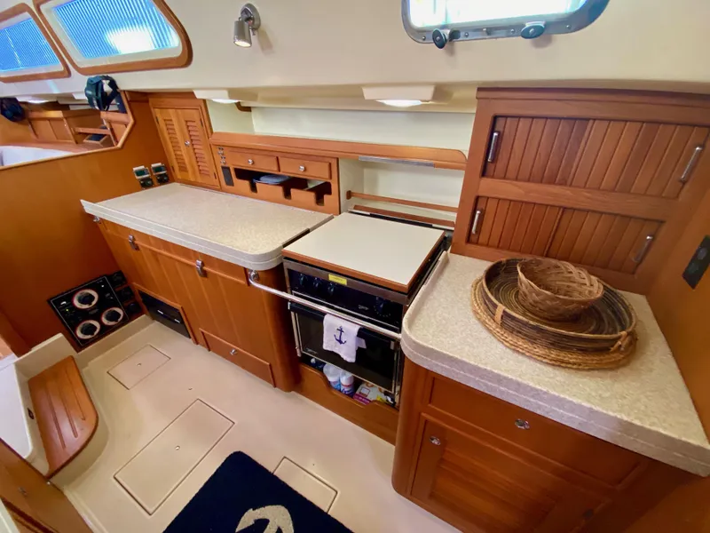 Slide: The Image of 2006 Island Packet 485 Center Cockpit galley with wood cabinetry and modern appliances. - 35