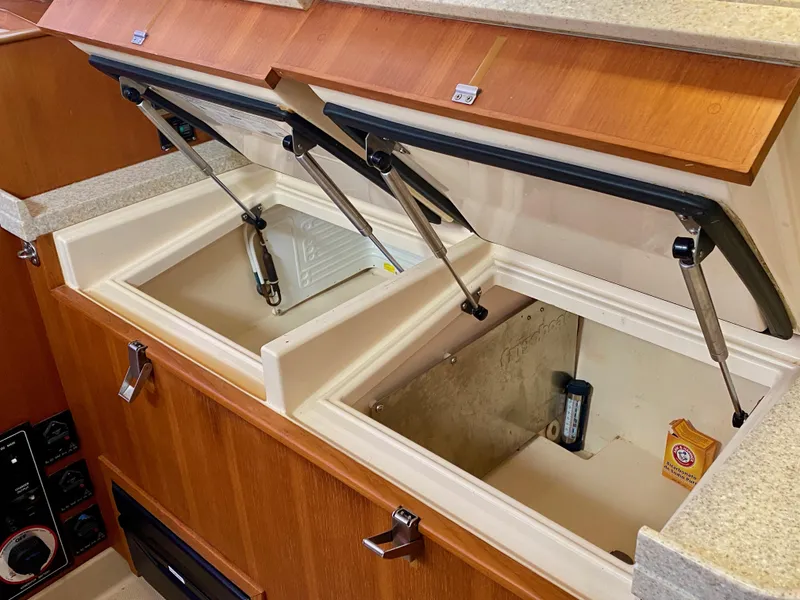 Slide: The Image of 2006 Island Packet 485 Center Cockpit interior storage compartments with open lids. - 37