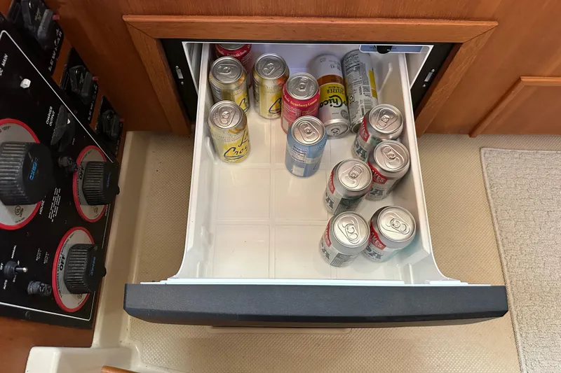 Slide: The Image of Drawer with assorted beverage cans in Island Packet 485 Center Cockpit, 2006 model. - 42