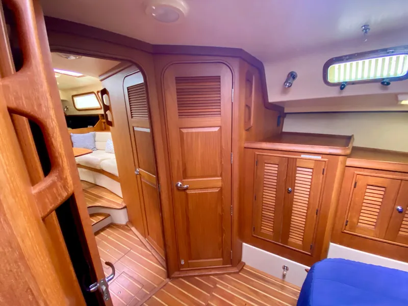 Slide: The Image of Interior of 2006 Island Packet 485 Center Cockpit with wooden cabinetry and cozy seating area. - 56