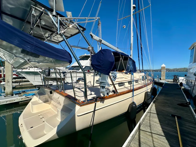 Slide: The Image of 2006 Island Packet 485 Center Cockpit sailboat docked at marina under clear blue sky. - 7