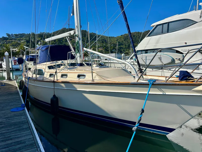 Slide: The Image of 2006 Island Packet 485 Center Cockpit sailboat docked at marina, clear blue sky. - 9
