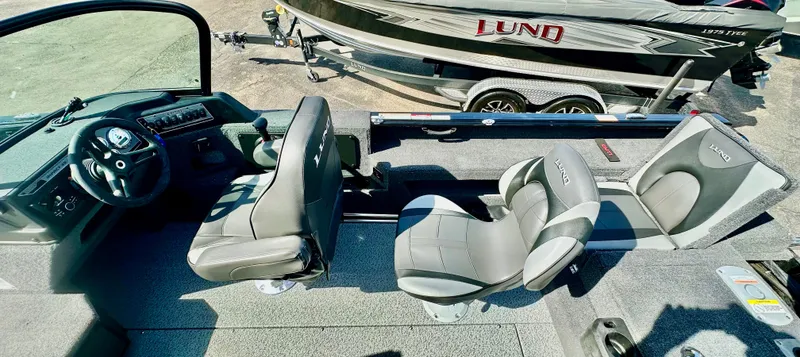 Slide: The Image of 2025 Lund 2075 IMPACT XS boat interior with seating and steering console. - 11