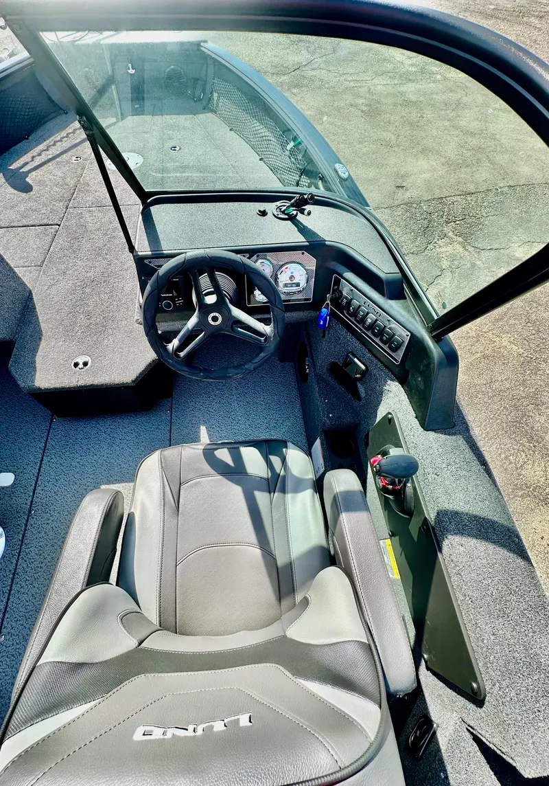 Slide: The Image of 2025 Lund 2075 IMPACT XS boat interior with steering wheel and seating. - 12