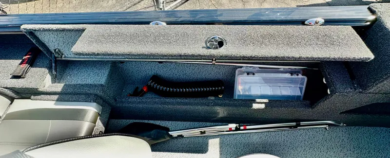 Slide: The Image of 2025 Lund 2075 IMPACT XS boat interior storage compartment with organized fishing gear. - 13