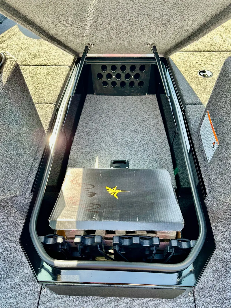 Slide: The Image of 2025 Lund 2075 IMPACT XS boat storage compartment with open lid, showcasing interior space. - 14