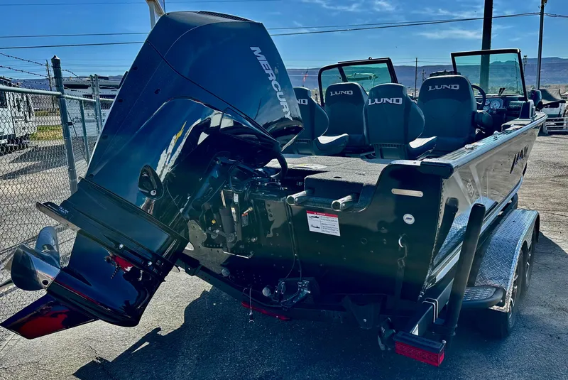 Slide: The Image of 2025 Lund 2075 IMPACT XS boat with Mercury outboard motor, parked on a trailer. - 3