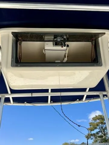 Slide: The Image of 2007 Jones Brothers 23 Bateau boat with open storage compartment under blue sky. - 8