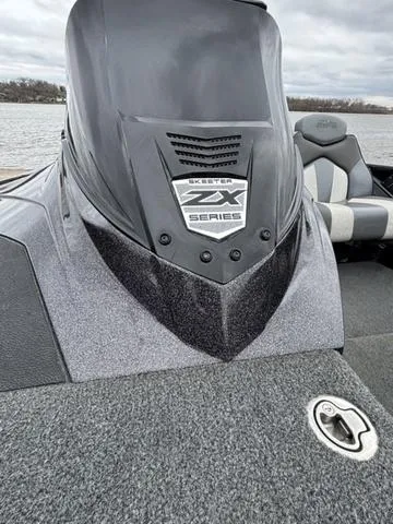 Slide: The Image of 2020 Skeeter ZX250 boat, close-up of console and seating, on a lake. - 16