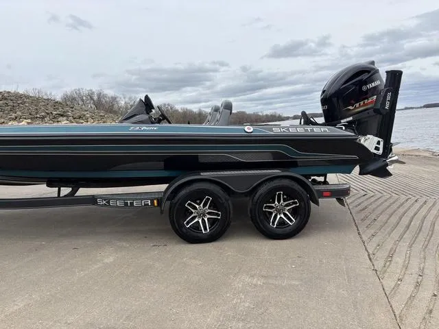 Slide: The Image of 2020 Skeeter ZX250 boat on trailer by a lake, featuring Yamaha outboard motor. - 6