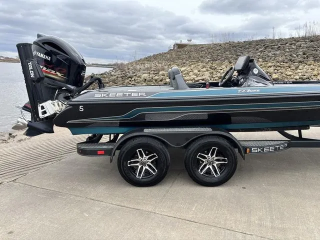 Slide: The Image of 2020 Skeeter ZX250 boat on trailer by a lake, featuring Yamaha engine. - 9