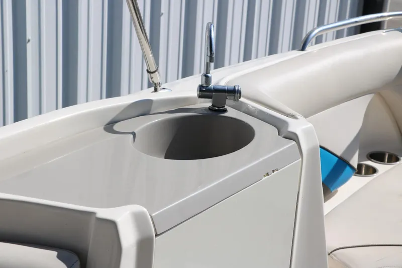 Slide: The Image of 2009 Hurricane FunDeck 226 OB boat sink with faucet, white interior, and cup holders. - 27