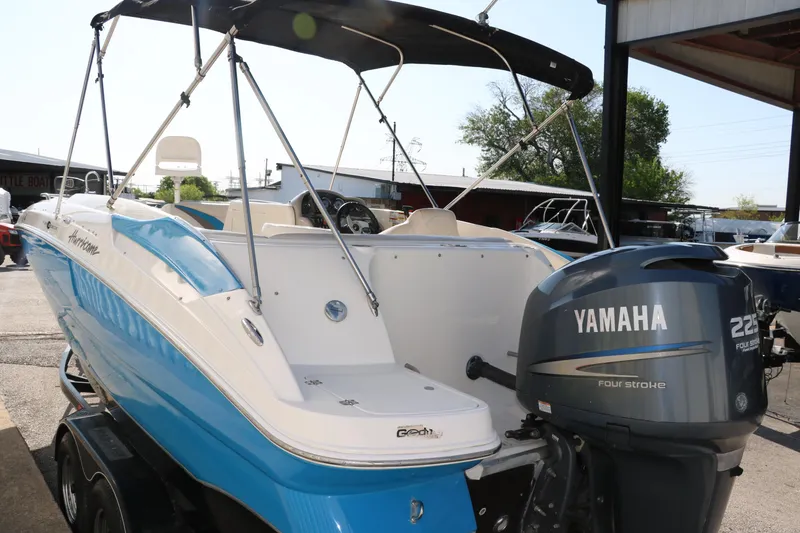 Slide: The Image of 2009 Hurricane FunDeck 226 OB boat with Yamaha 225 engine, parked outdoors. - 5