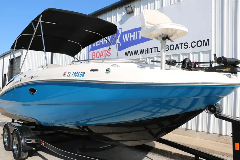 Slide: The Image of 2009 Hurricane FunDeck 226 OB boat with blue hull on trailer, parked outside dealership. - 8