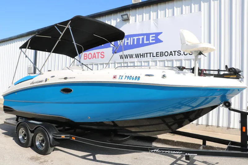 Slide: The Image of 2009 Hurricane FunDeck 226 OB boat with blue hull on trailer, parked outside Whittle Boats. - 9