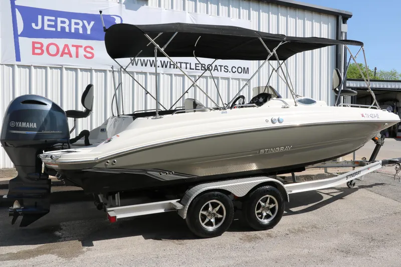 Slide: The Image of 2018 Stingray 212 SC boat on trailer with Yamaha engine, parked at dealership. - 14