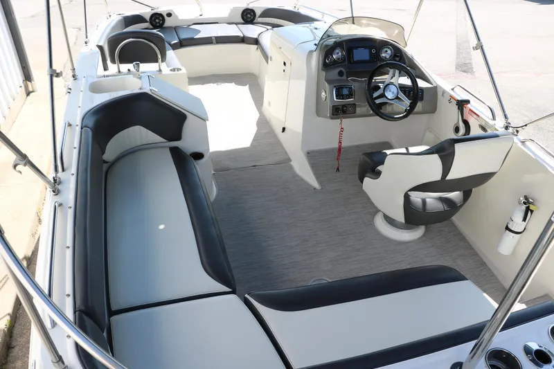 Slide: The Image of 2018 Stingray 212 SC boat interior with seating and steering console. - 15