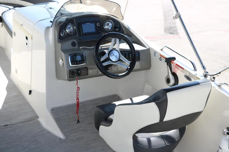Slide: The Image of 2018 Stingray 212 SC boat cockpit with steering wheel and control panel. - 17