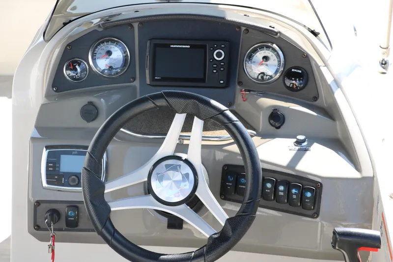 Slide: The Image of 2018 Stingray 212 SC boat dashboard with steering wheel and control panel. - 21