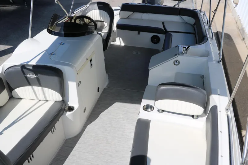Slide: The Image of 2018 Stingray 212 SC boat interior with seating and steering console. - 22
