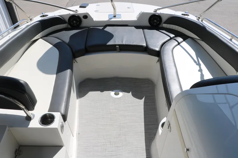 Slide: The Image of 2018 Stingray 212 SC boat interior with cushioned seating and cup holders. - 25