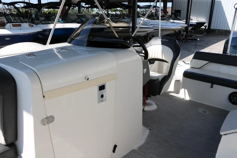 Slide: The Image of 2018 Stingray 212 SC boat interior with steering wheel and seating area. - 26