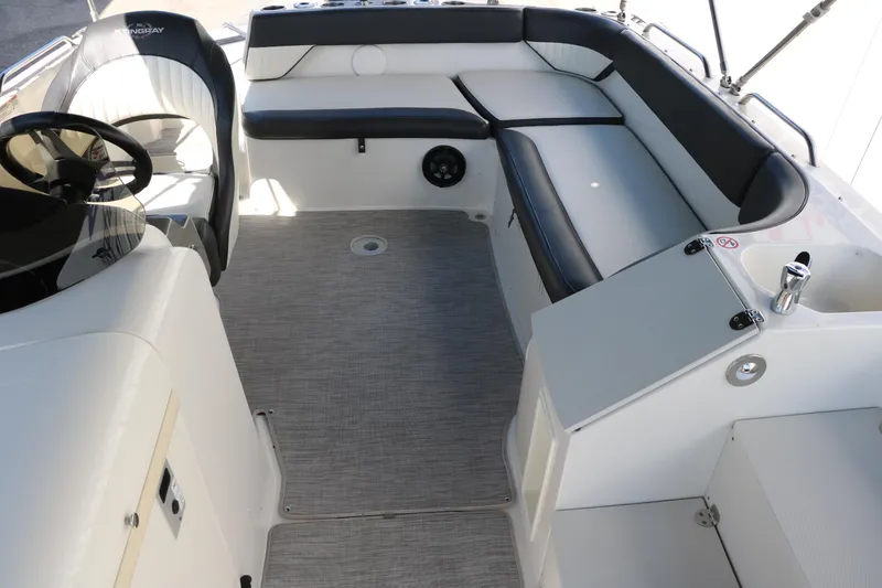 Slide: The Image of 2018 Stingray 212 SC boat interior with seating and steering wheel. - 27