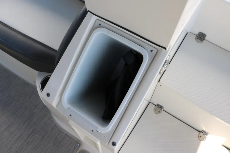 Slide: The Image of 2018 Stingray 212 SC boat storage compartment with open lid, showcasing interior space. - 29