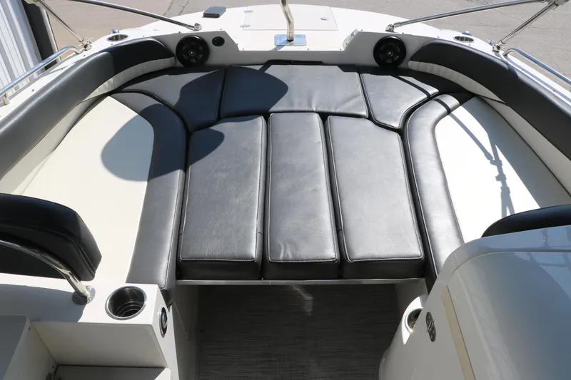 Slide: The Image of 2018 Stingray 212 SC boat interior with black leather seating and cup holders. - 33