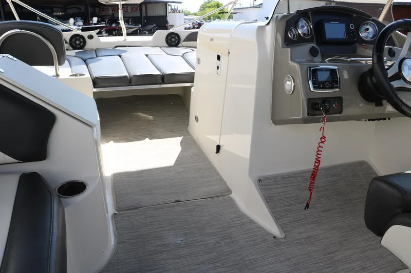 Slide: The Image of 2018 Stingray 212 SC boat interior with seating, dashboard, and steering wheel. - 36