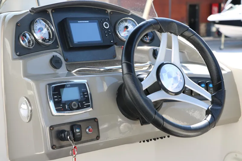 Slide: The Image of 2018 Stingray 212 SC boat dashboard with steering wheel and control panel. - 37