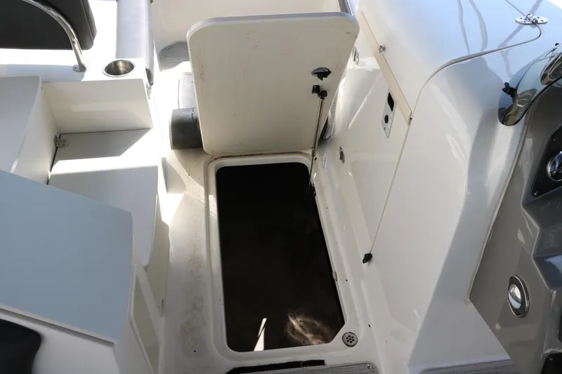 Slide: The Image of 2018 Stingray 212 SC boat interior with open storage compartment. - 43