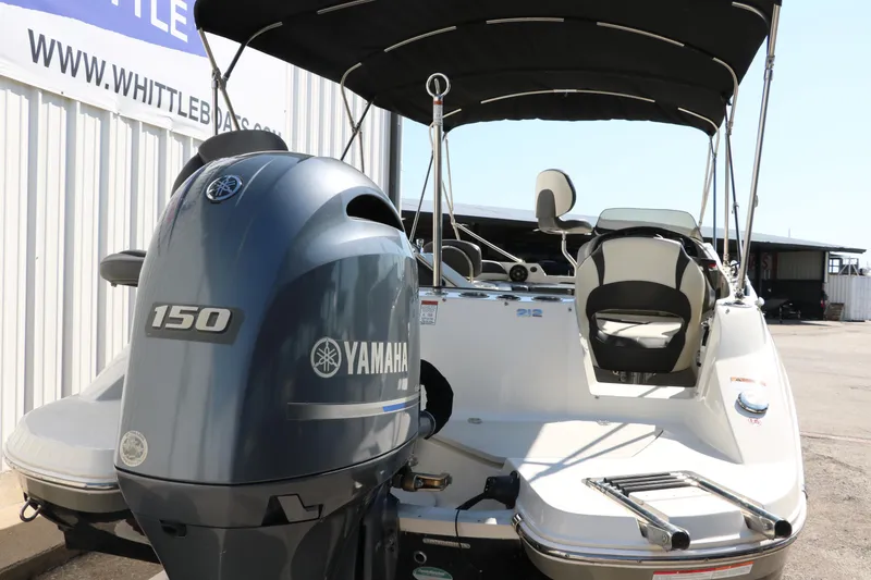 Slide: The Image of 2018 Stingray 212 SC boat with Yamaha 150 engine, docked near a building. - 5