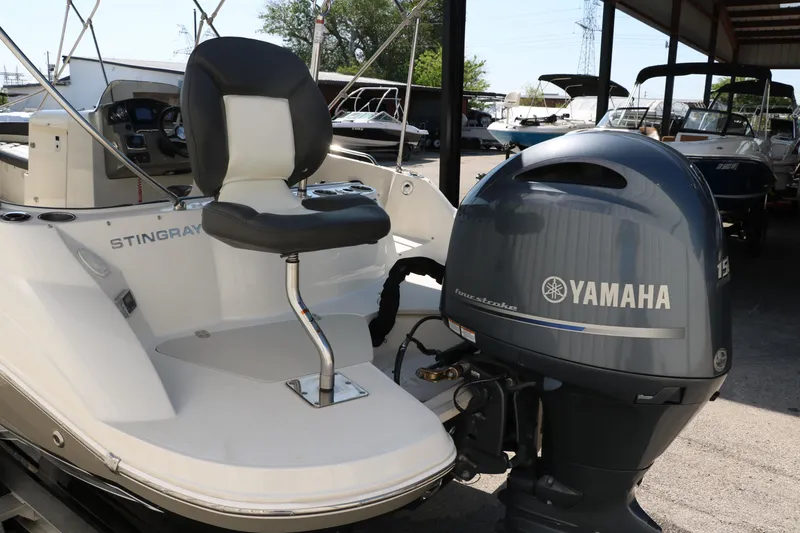 Slide: The Image of 2018 Stingray 212 SC boat with Yamaha outboard motor in a marina setting. - 7