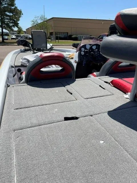 Slide: The Image of 2007 ProCraft 210 Super Pro SC boat interior with gray and red seating, parked outdoors. - 4