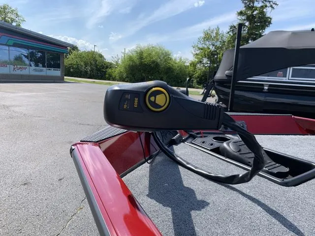 Slide: The Image of 2023 Ranger RT178 boat with trolling motor control, parked outdoors on a sunny day. - 2