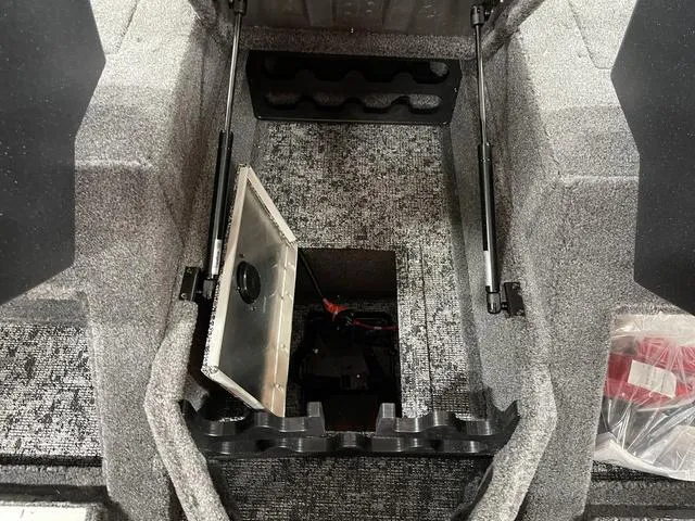 Slide: The Image of 2025 Tracker Pro Guide™ V-175 Combo boat storage compartment with open hatch and carpeted interior. - 20