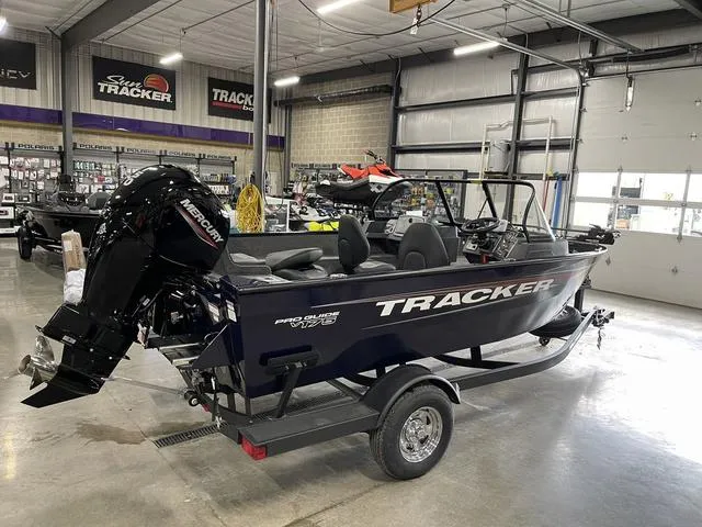 Slide: The Image of 2025 Tracker Pro Guide V-175 Combo boat in showroom, featuring Mercury outboard motor. - 3