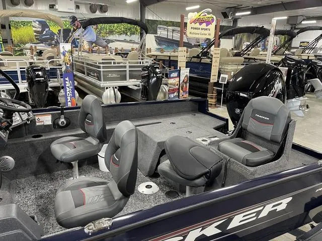 Slide: The Image of 2025 Tracker Pro Guide™ V-175 Combo boat interior with seating and controls in showroom. - 9