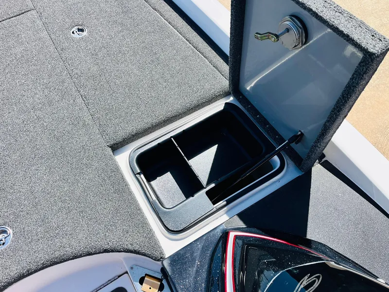 Slide: The Image of 2022 Caymas CX 21 PRO boat storage compartment with open lid and carpeted interior. - 31