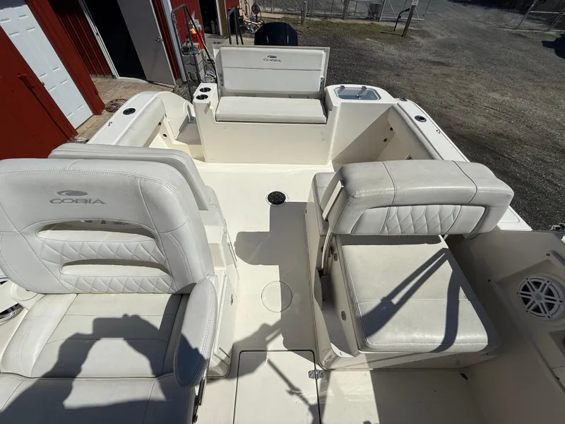Slide: The Image of 2023 Cobia 220 Dual Console boat interior with white seating and storage compartments. - 12