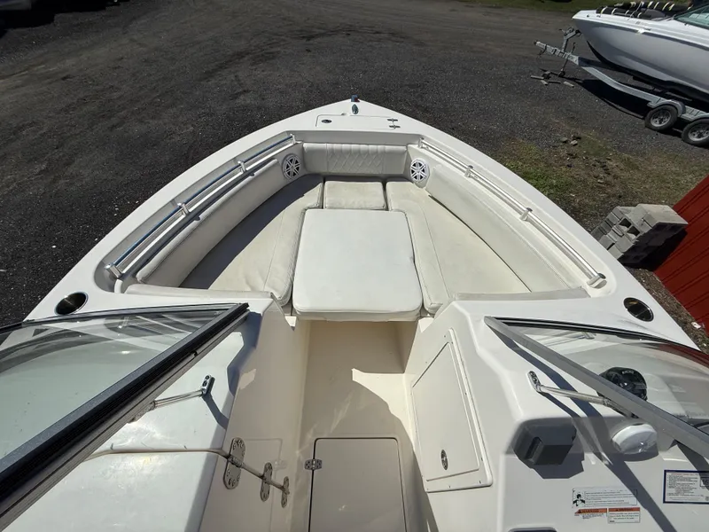 Slide: The Image of 2023 Cobia 220 Dual Console boat interior with white seating and storage compartments. - 13