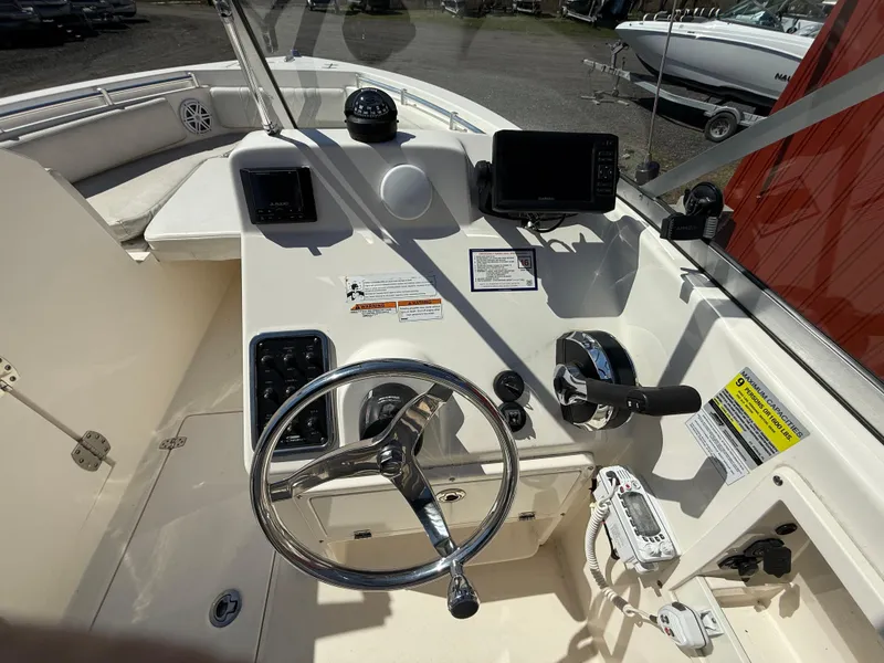 Slide: The Image of 2023 Cobia 220 Dual Console boat dashboard with steering wheel and navigation controls. - 15