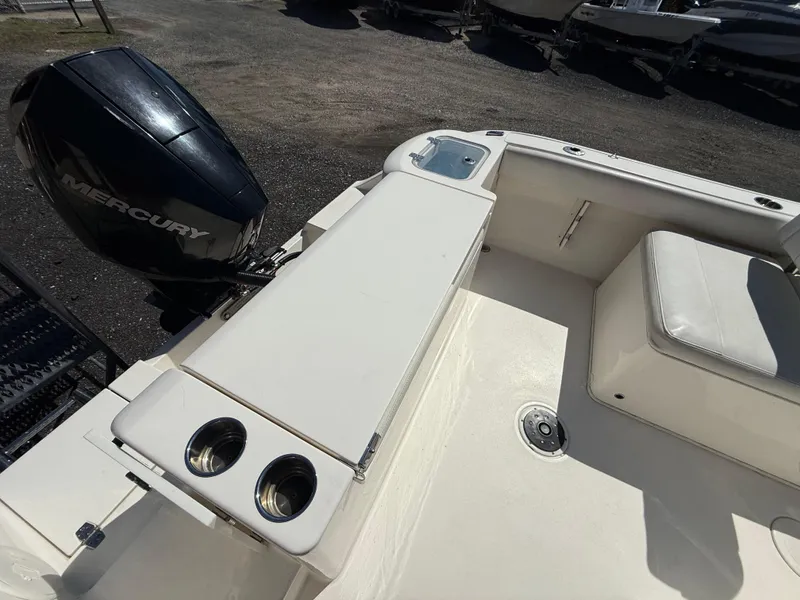 Slide: The Image of 2023 Cobia 220 Dual Console boat interior with Mercury engine and seating area. - 18