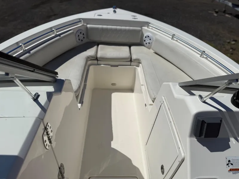 Slide: The Image of 2023 Cobia 220 Dual Console boat interior with cushioned seating and storage compartments. - 19
