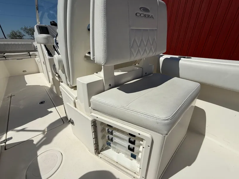 Slide: The Image of 2023 Cobia 220 Dual Console boat interior with white seating and storage compartment. - 20