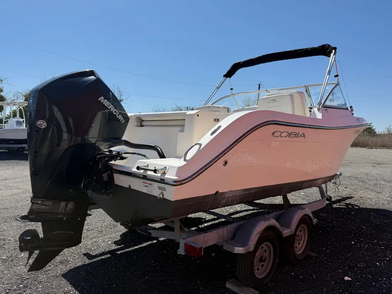 Slide: The Image of 2023 Cobia 220 Dual Console boat on trailer with Mercury outboard engine. - 5