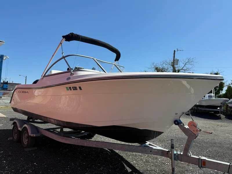 Slide: The Image of 2023 Cobia 220 Dual Console boat on a trailer under clear blue sky. - 7