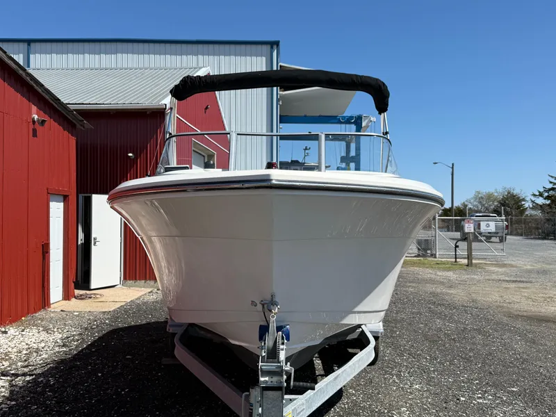 Slide: The Image of 2023 Cobia 220 Dual Console boat on trailer near red building. - 8